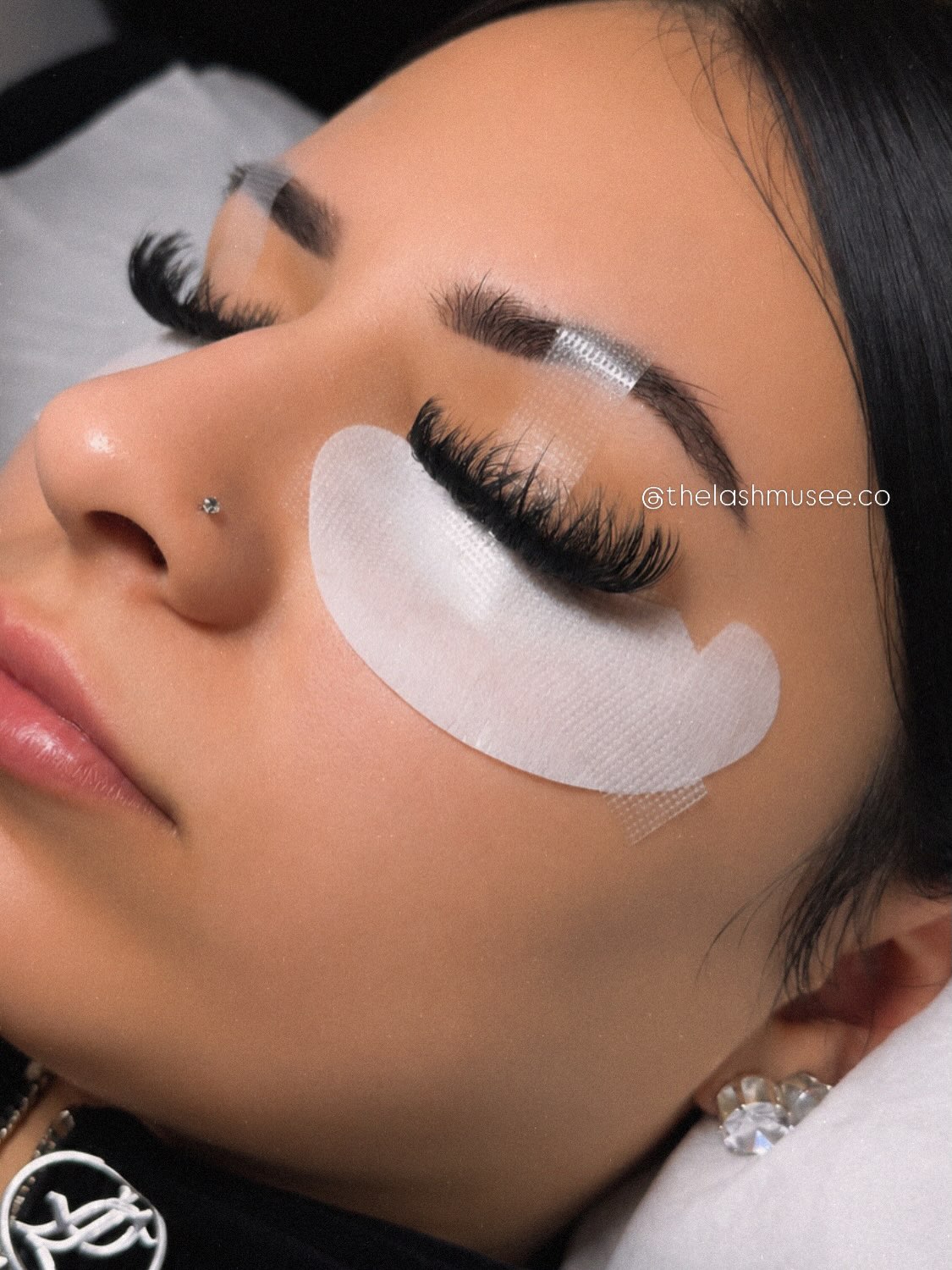Lash application in progress with protective eye pads